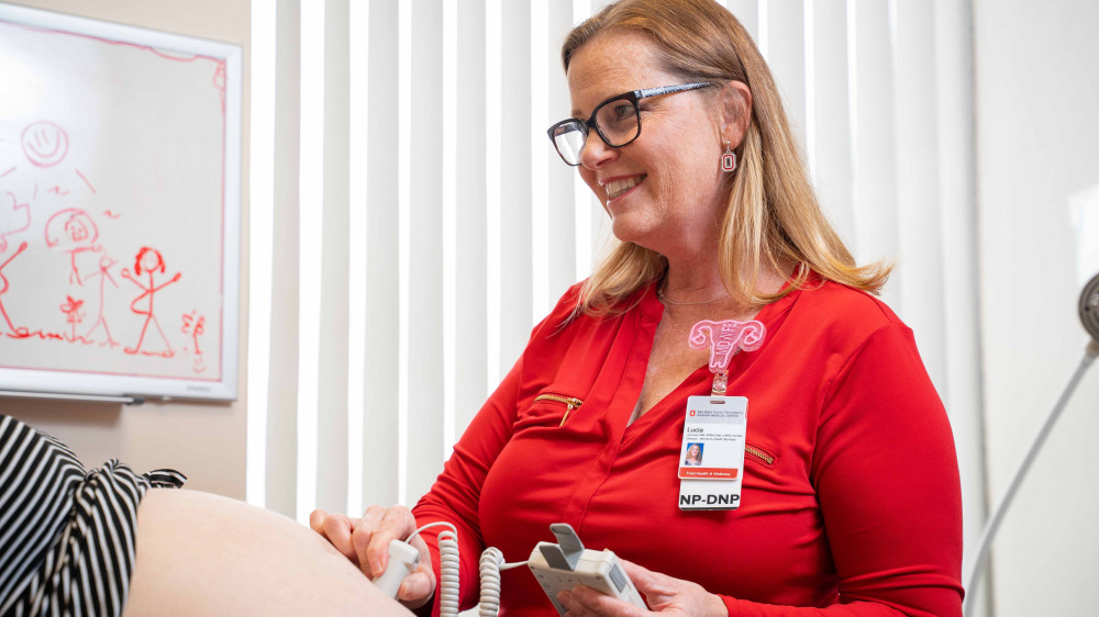 woman performing ultrasound on pregnant patient